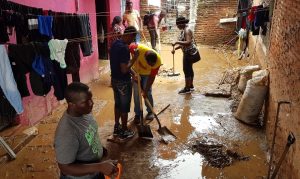 Migrantes centroamericanos y extra continentales ayudan en limpieza en viviendas y calles afectadas por la lluvia